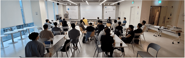 창이 밝은 강의실에서 참여자들이 연단 쪽 발표를 듣는 3회차 행사장
