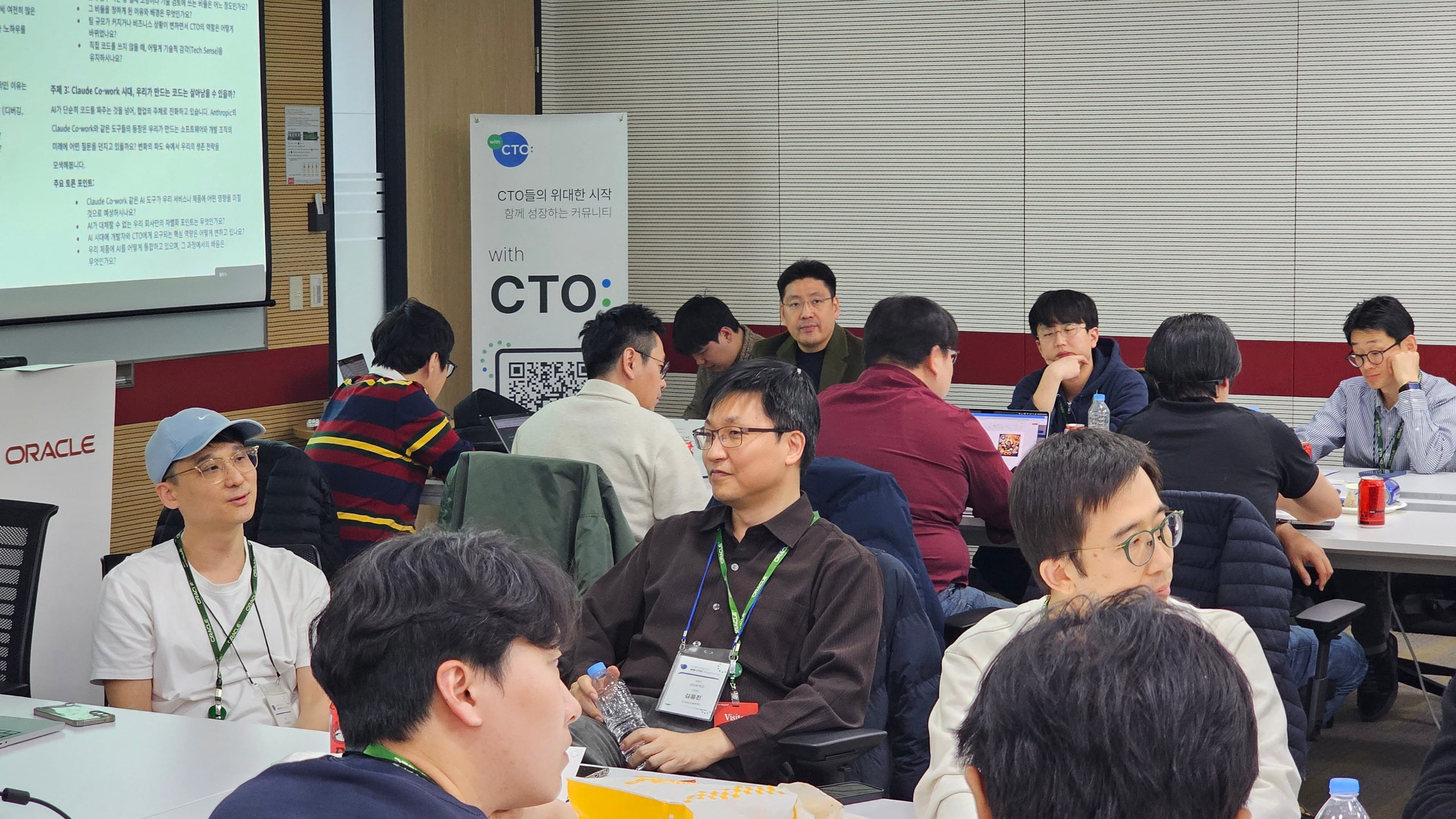 Claude Co-work 토론 주제가 뜬 화면과 with CTO: 배너 옆에서 명찰을 건 참여자들이 테이블별로 대화하는 모습